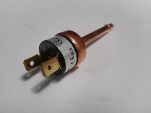 HD-Schalter von Remeha mit zwei Steckklemmen und einem Kupferkörper. Der Schalter hat eine runde Basis und ist für elektrische Anwendungen konzipiert.